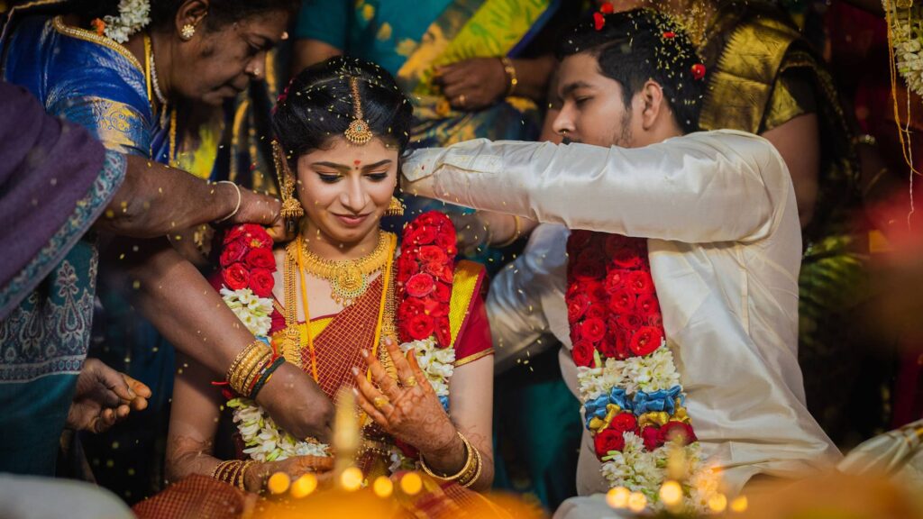 Traditional South Indian wedding moment of the groom tying the mangalsutra, beautifully captured by candid wedding photographers in Hyderabad.